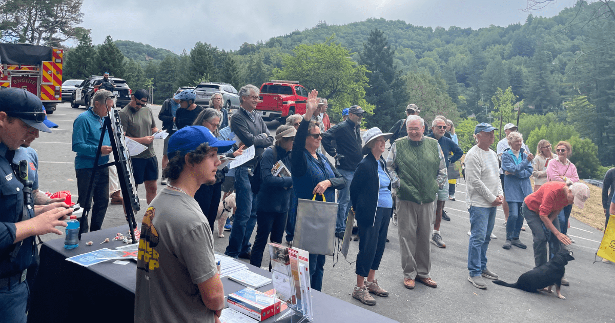 group of people standing outside watching a presentation
