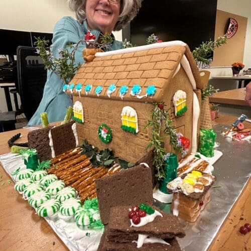 gingerbread house with person behind it