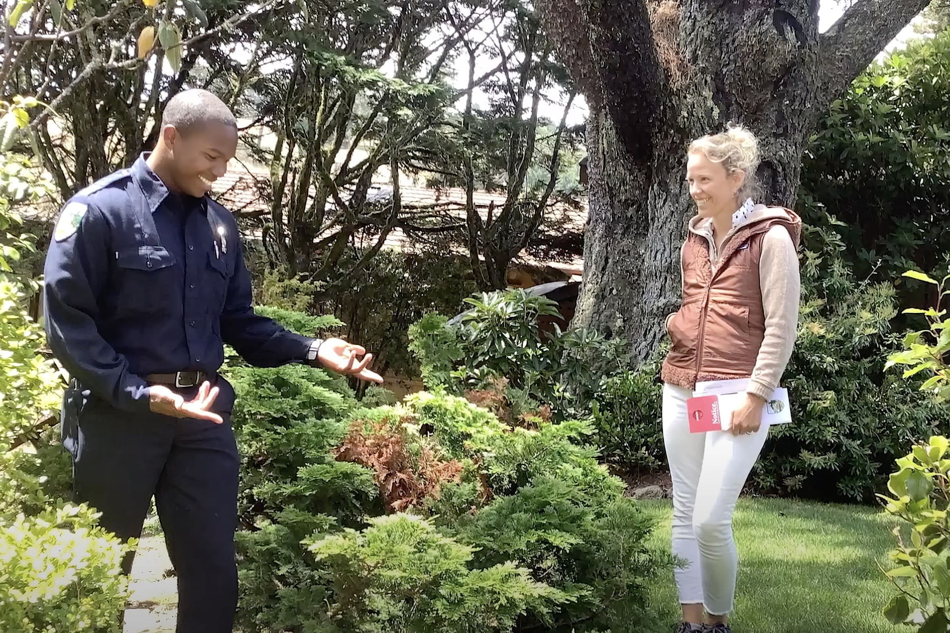 man and women outside talking among vegetation