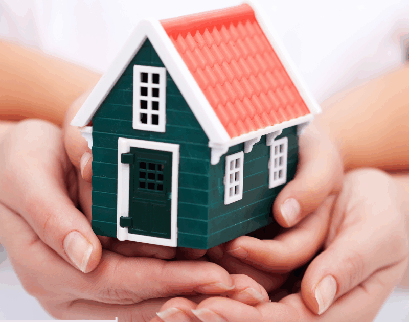 hands holding a toy house