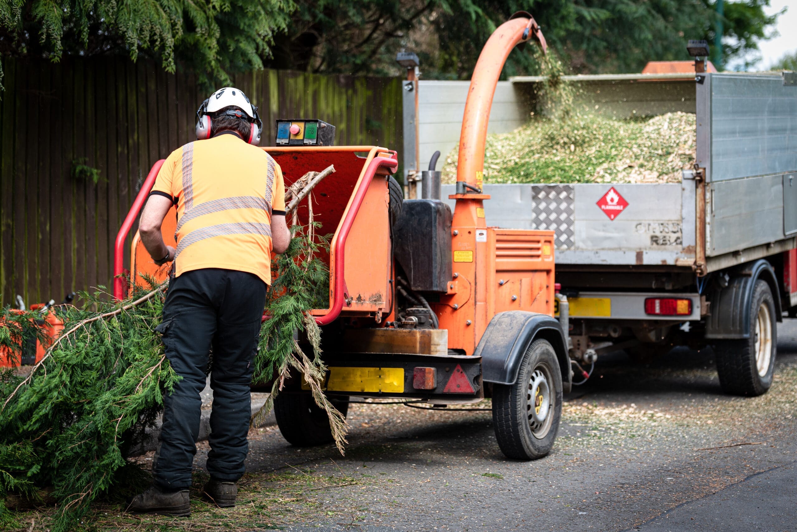 Male,Arborist,Using,A,Working,Wood,Chipper,Machine.the,Tree,Surgeon