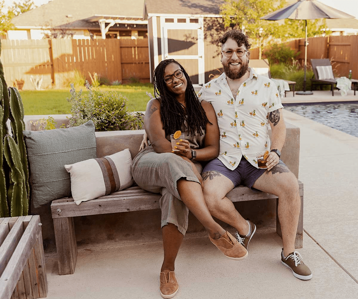Young couple sitting on a bench enjoying a drink
